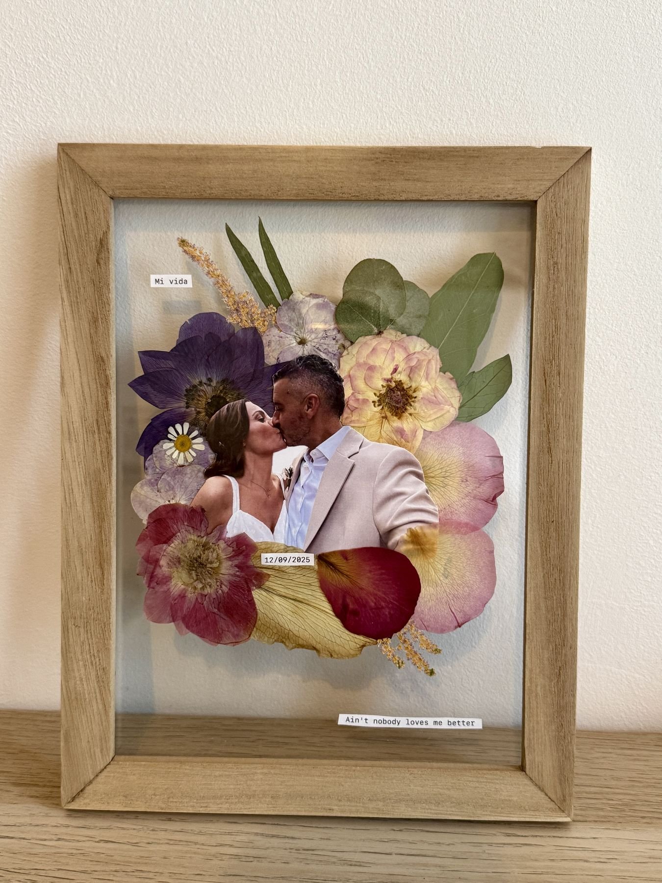 Cuadro con flores de boda y la foto de la pareja