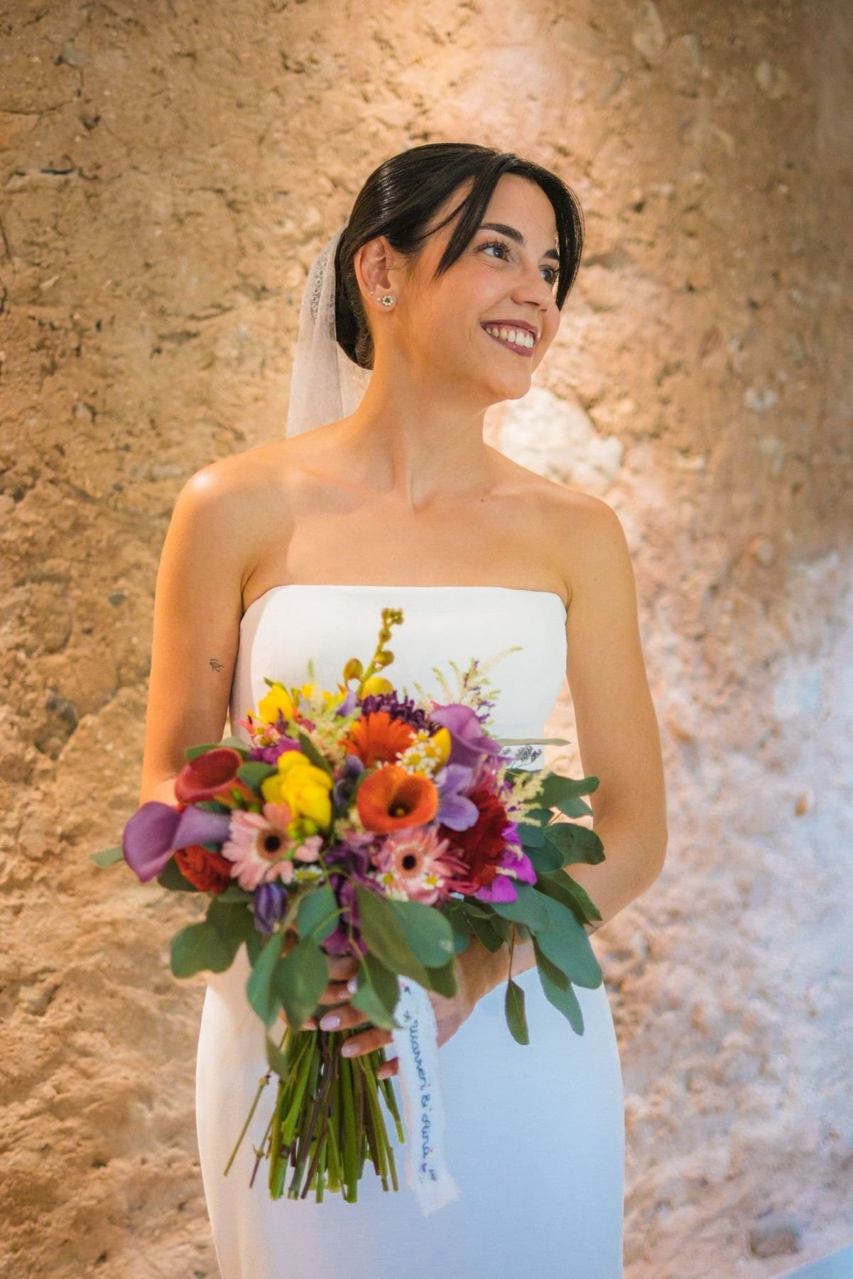 Novia sonriendo con su ramo de flores de colores